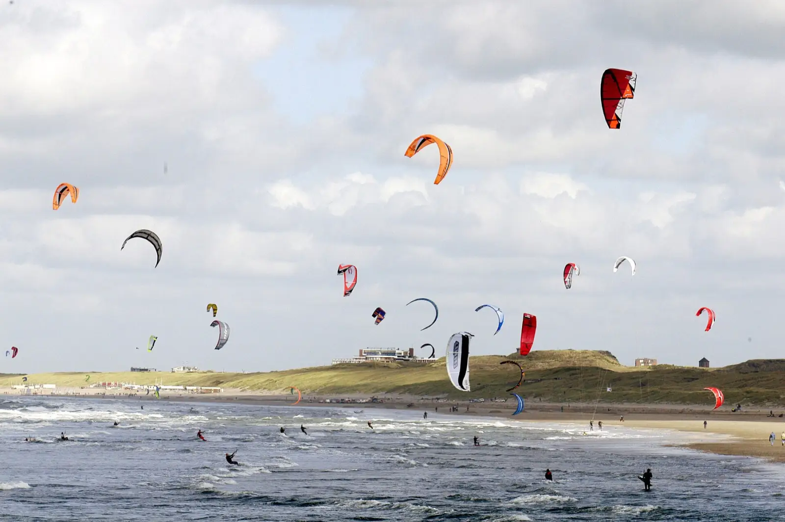 Tientallen kites in de lucht boven de branding bij Wijk aan Zee